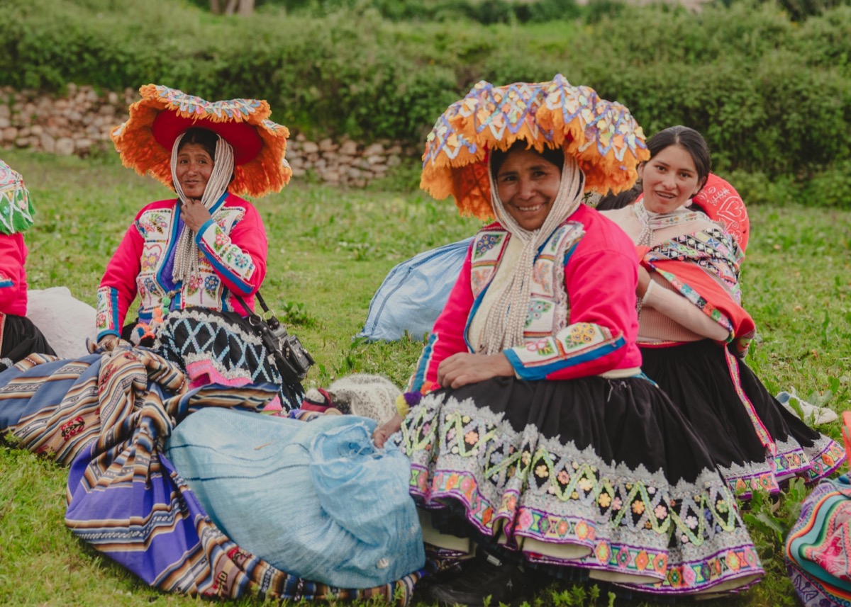 Andean women in traditional Chinchero dress and headdresses at a Colores de Abundancia gathering, Cusco, Peru
