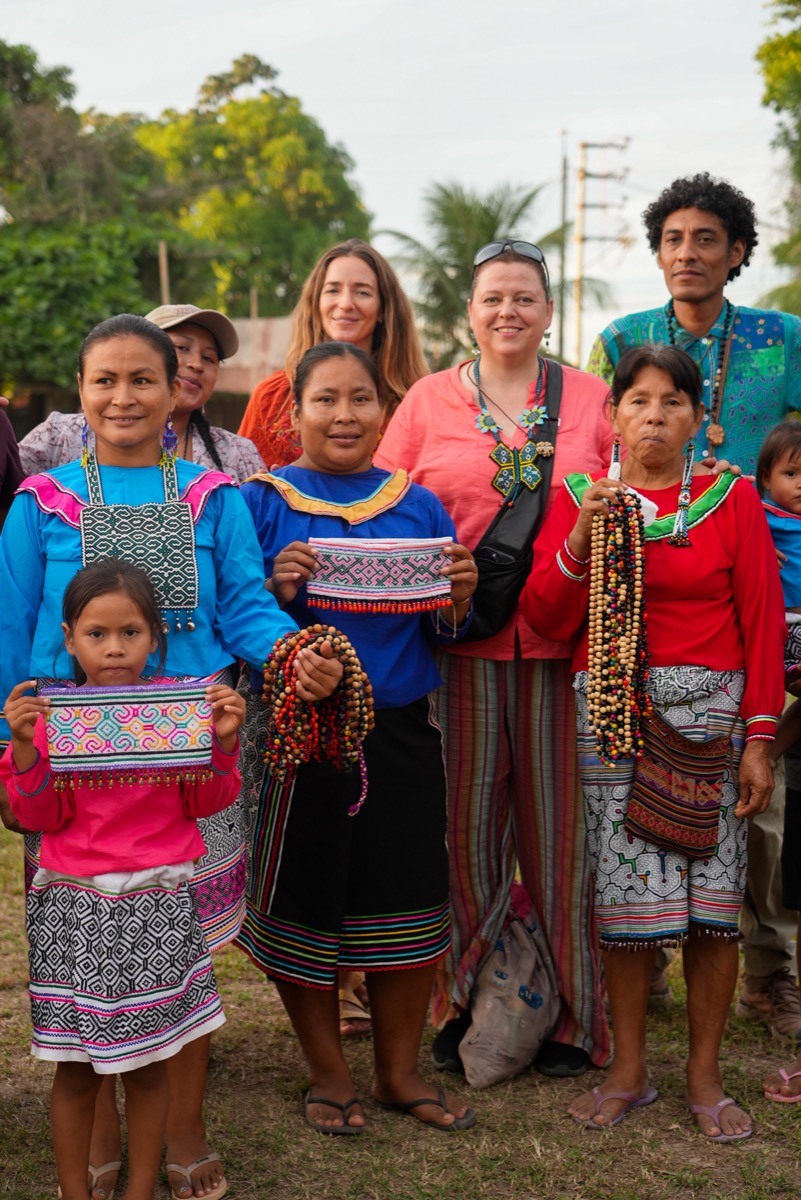 Shipibo-Konibo artisans from Paohyan with visitors, displaying kené embroidered textiles and beaded jewelry, Loreto, Peru