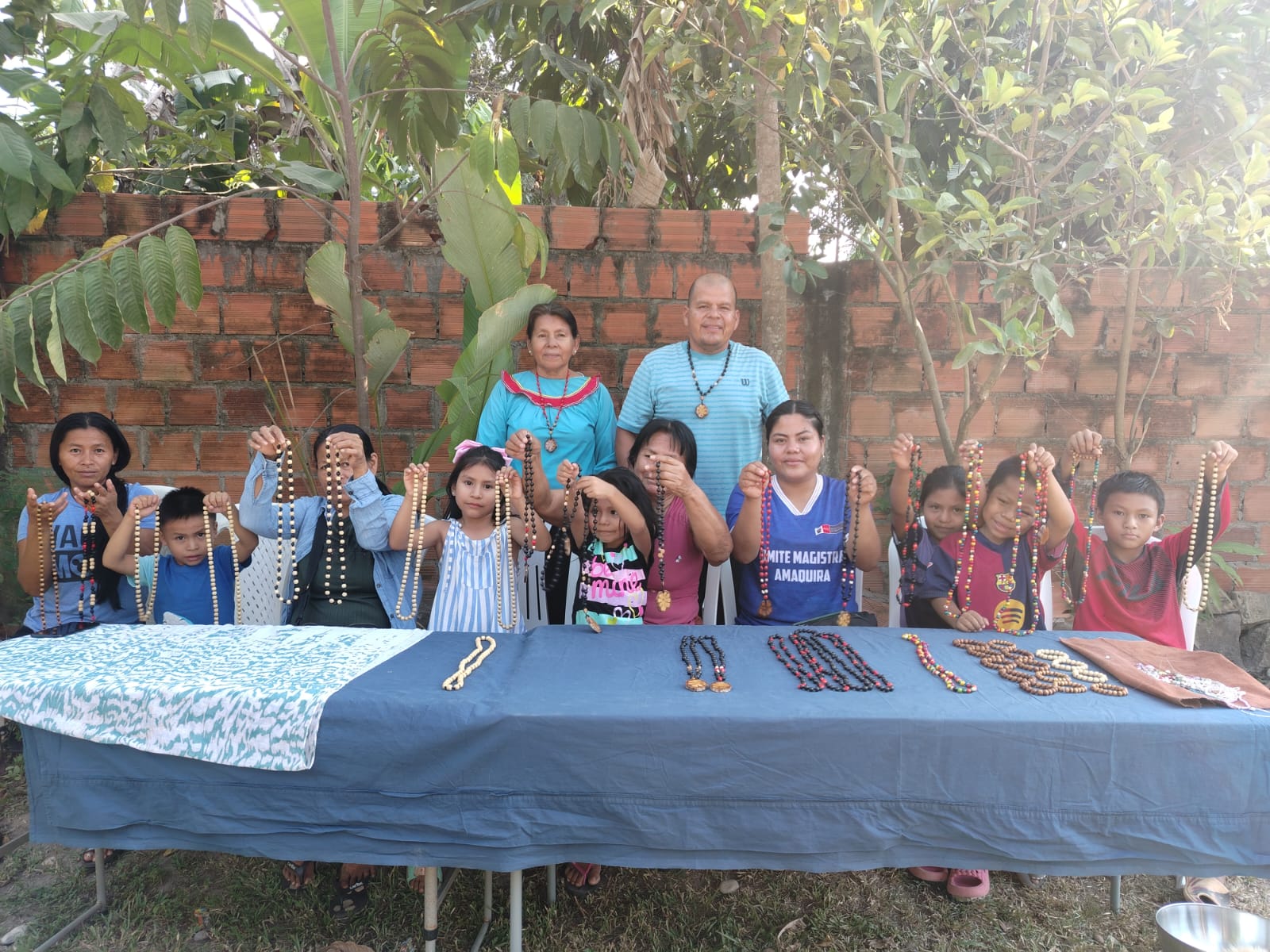 Shipibo-Konibo children and adults from Paohyan proudly displaying handmade beaded necklaces at a jewelry workshop led by Ida Castro Rojas, Loreto, Peru