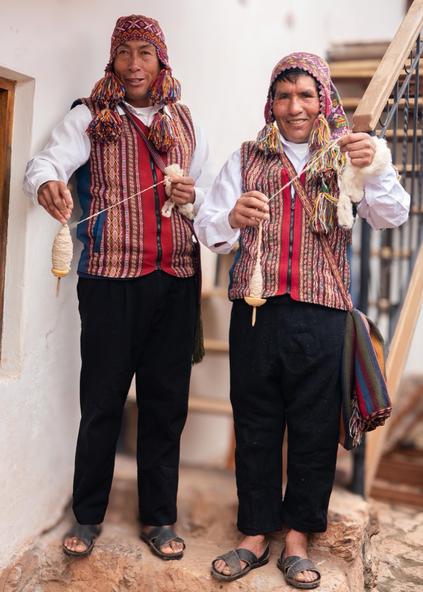 Jacinto Singona Puma and Artemio Marcavillaca Castro in traditional Chinchero dress holding drop spindles, Cusco, Peru