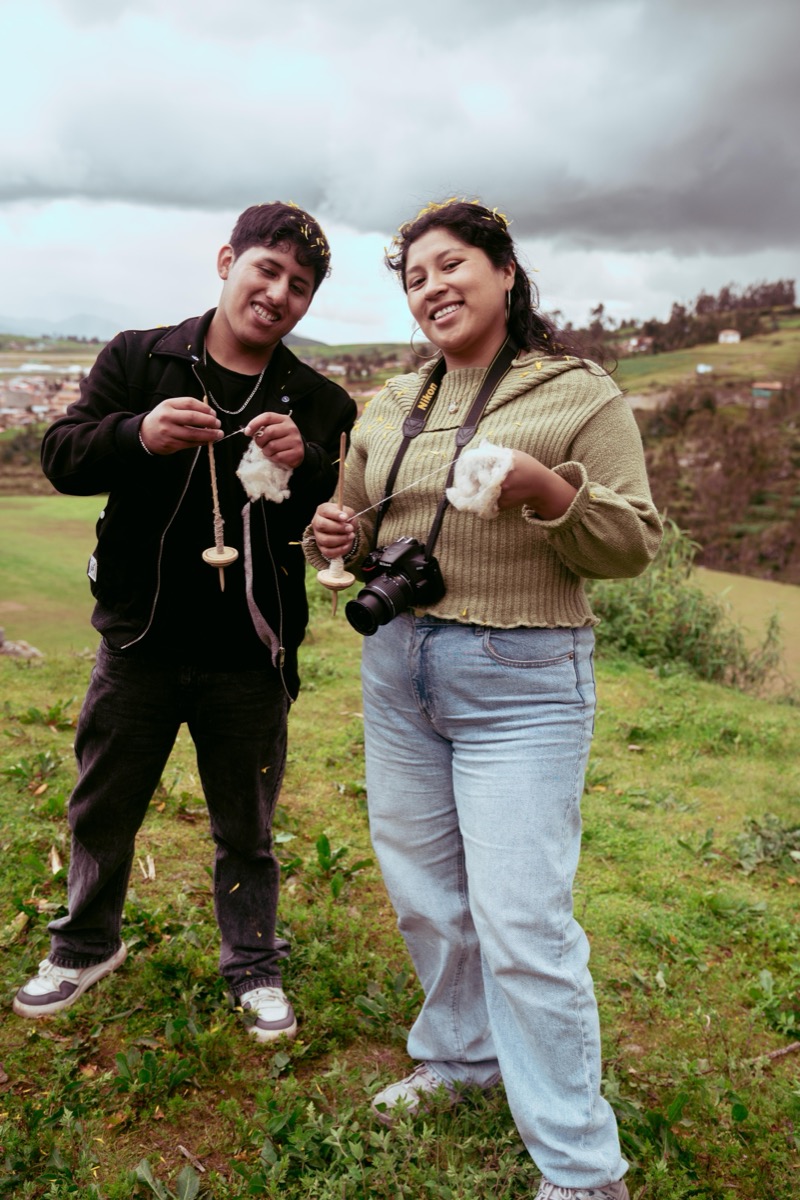 Robert Singona Pumacahua and Katterin Flores, artists from Chinchero, Peru, spinning wool together outdoors
